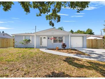 Charming single-story home with a well-maintained front yard, walkway, and attached garage at 4220 Oakfield Ave, Holiday, FL 34691