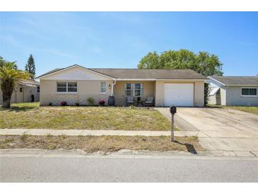 Charming single-story home with a well-manicured lawn, quaint front porch, and attached garage at 6416 Lomand Ave, New Port Richey, FL 34653