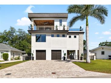 Stunning three-story home with private balconies, a two-car garage, and a beautiful paver driveway at 706 S Davis Blvd, Tampa, FL 33606