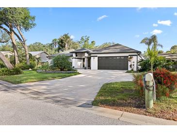 Charming single-story home featuring a manicured lawn, mature trees, and a two-car garage at 1004 Hollyberry Ct, Brandon, FL 33511