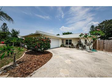 Single-story home with a well-maintained front yard, driveway, and attached garage on a sunny day at 1615 Stonehaven Way, Tarpon Springs, FL 34689