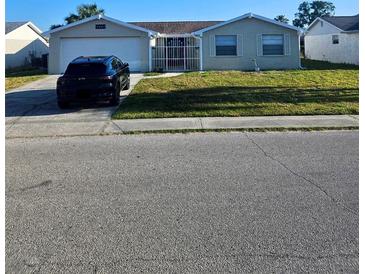 Charming single-story home featuring an attached garage and well-maintained front yard at 6241 Westport Dr, Port Richey, FL 34668