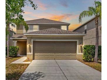 Charming two-story home with a well-manicured lawn, two-car garage and tropical landscaping at 2122 Richwood Pike Dr, Ruskin, FL 33570