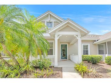 Charming single-story home features a covered front porch with lovely landscaping and a welcoming green front door at 215 Oceania Ct, Apollo Beach, FL 33572