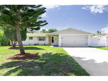 Charming single-story home with a well-manicured lawn and a quaint, inviting front porch at 512 Flamingo Dr, Apollo Beach, FL 33572