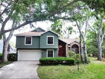 Charming two-story home with a red front door, two-car garage, and beautiful landscaping at 11783 Ashley Ct, Seminole, FL 33772