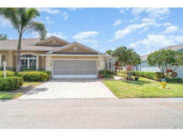 Charming single-story home featuring a two-car garage, brick paver driveway, and well-maintained landscaping at 1231 Corinth Greens Dr, Sun City Center, FL 33573