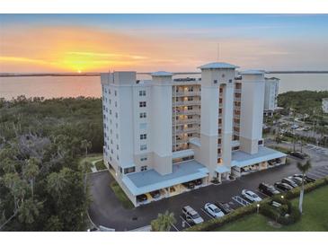 Stunning aerial view of condo building near the water at sunset with beautiful landscaping and covered parking at 2625 Terra Ceia Bay Blvd # 406, Palmetto, FL 34221