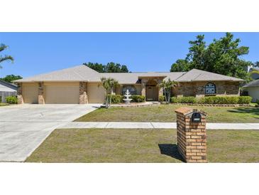 Charming brick home featuring a well-manicured lawn, a fountain, and a two-car garage at 2914 Timber Knoll Dr, Valrico, FL 33596