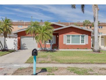Charming single-story home with red exterior, garage, and a well-maintained front lawn with a mailbox at 3516 Casablanca Ave, St Pete Beach, FL 33706