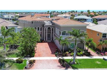 Stunning waterfront home featuring a brick driveway and lush tropical landscaping at 6201 Marbella Blvd, Apollo Beach, FL 33572