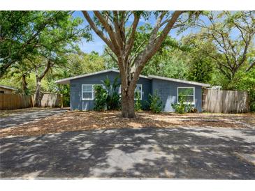 Charming single-story home featuring a blue exterior, mature trees and well kept landscaping at 6225 76Th N Ave, Pinellas Park, FL 33781
