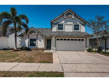 Charming two-story home featuring a two-car garage, manicured lawn, and lush landscaping for enhanced curb appeal at 10906 Kenbrook Dr, Riverview, FL 33578