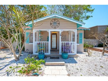 Charming cottage with a front porch, light blue shutters and a quaint compass decoration at 1507 Legion Ln, Indian Rocks Beach, FL 33785