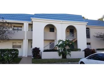 Charming condo building featuring a distinctive blue roof and well-maintained landscaping at 1975 W Bay Dr # 207, Largo, FL 33770