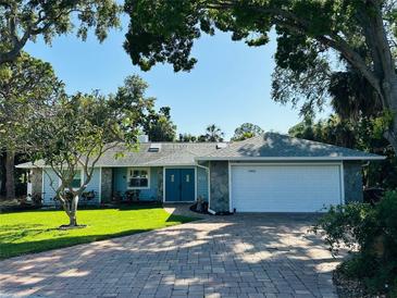 Charming home with a well-manicured lawn, stone accents, and a double-door entrance, set under mature trees at 2860 58Th S Cir, St Petersburg, FL 33712