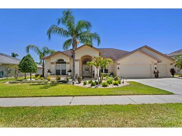 Charming home featuring well-manicured landscaping, a two-car garage, and a welcoming entrance at 5113 Epping Ln, Zephyrhills, FL 33541