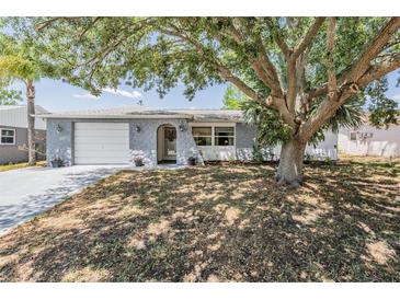 Charming single-story home with stone accents, a front-entry garage, and mature trees at 6333 Aberdeen Ave, New Port Richey, FL 34653