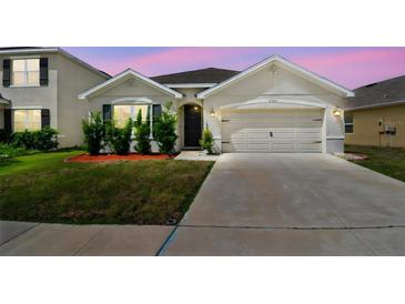 Charming single-story home featuring a two-car garage and well-manicured lawn at 8105 Bilston Village Ln, Gibsonton, FL 33534