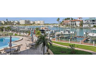 Enjoy poolside relaxation at this waterfront property with boat docks and lush landscaping at 936 Pinellas Bayway S # T-5, Tierra Verde, FL 33715