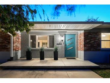 Charming home featuring a modern teal door and a well-maintained brick facade at 222 N Clearview Ave, Tampa, FL 33609