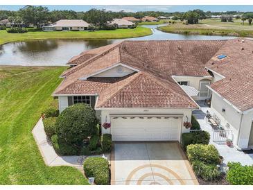 Inviting single-Gathering home featuring a well-manicured lawn, lush greenery, and a decorative driveway at 2602 Novack Ct, Sun City Center, FL 33573
