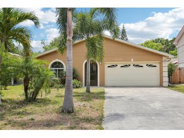 Charming single-story home with a two-car garage and a well-maintained front yard with palm trees at 3176 Duane Ave, Oldsmar, FL 34677