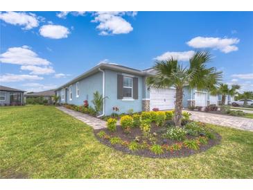 Charming single-story home with a well-manicured lawn and colorful flower beds at 3765 Maxwell Park Dr, Sun City Center, FL 33573