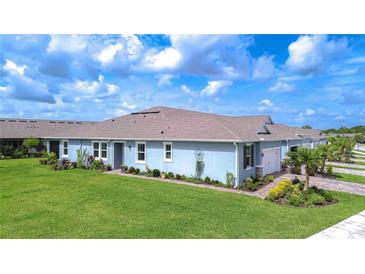 Charming single-story home with lush green lawn and well-manicured landscaping under a bright blue sky at 3765 Maxwell Park Dr, Sun City Center, FL 33573