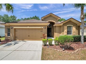 Beautiful single Gathering home featuring a two-car garage, neat landscaping and tan-colored exterior at 4500 Fieldview Cir, Wesley Chapel, FL 33545