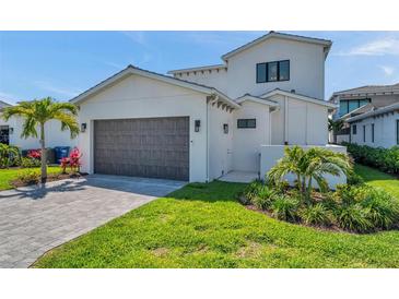 Beautiful two-story home with a large garage, well-manicured lawn, and lush tropical landscaping at 5917 Cat Claw Ln, Bradenton, FL 34210