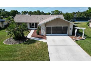 Charming single-story home with well-manicured lawn, mature palm trees, and a screened two-car garage at 3276 Hilary Cir, Palm Harbor, FL 34684