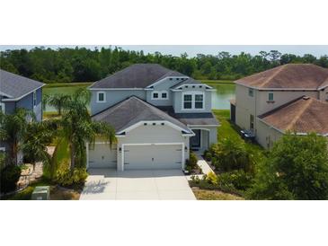 Beautiful two-story home with a two-car garage, situated near a pond and lush green trees at 33176 Whisper Pointe Dr, Wesley Chapel, FL 33545