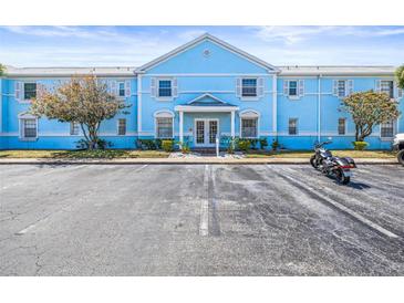 Inviting condo complex featuring charming blue facade, well-maintained landscaping and ample parking at 5003 Starfish Dr Se # B, St Petersburg, FL 33705