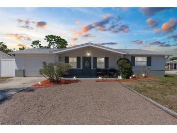 Charming single-story home with a well-maintained gravel front yard and inviting exterior lighting at 5117 Fitchburg Dr, Holiday, FL 34690