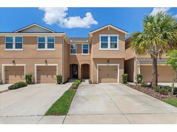 Charming townhome exterior features a well-manicured lawn, private garages, and a welcoming entrance at 6225 Scarlet Darter Way, Tampa, FL 33625