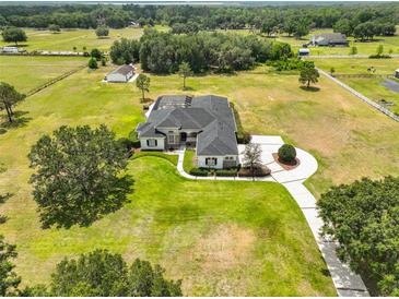 Sprawling estate featuring lush landscaping, a large circular driveway, and a screened-in pool at 18423 Lithia Towne Rd, Lithia, FL 33547