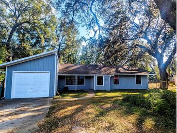 Charming single-story home featuring attached garage and a neatly maintained front yard with mature trees at 37654 Eiland Blvd, Zephyrhills, FL 33542