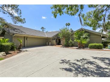 Spacious home featuring a large driveway, mature trees, and a well-maintained exterior at 5335 Sand Crane Ct, Wesley Chapel, FL 33543