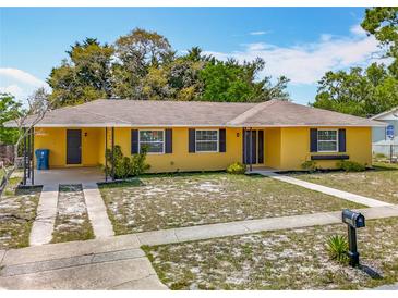 Charming yellow single-story home featuring dark shutters, a brown roof, and a well-kept yard at 7280 Tarrytown Dr, Spring Hill, FL 34606