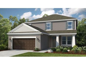 Charming two-story home with gray siding, a two-car garage, and beautifully landscaped front yard at 735 Sky Shade Dr, Apollo Beach, FL 33572