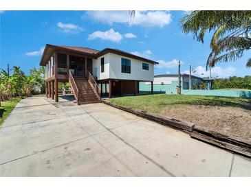 Coastal home featuring a raised foundation, screened porch, and a spacious driveway at 9118 Brunswick Ln, Tampa, FL 33615