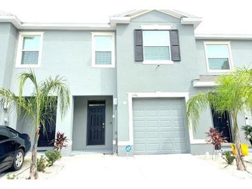 Modern townhome featuring a one-car garage, a neutral color scheme, and simple landscaping at 1490 Colt Creek Pl, Wesley Chapel, FL 33543