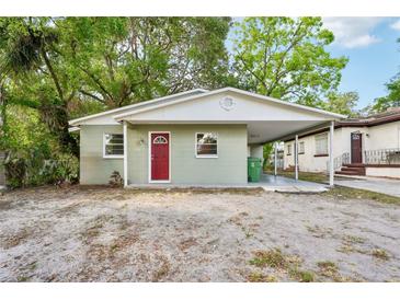 Charming single-story home with a carport, fresh paint, and a vibrant red door at 1720 W Arch St, Tampa, FL 33607