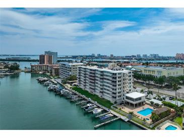 Waterfront condo complex featuring boat docks, swimming pool, and views of the city skyline at 223 Island Way # 5D, Clearwater Beach, FL 33767