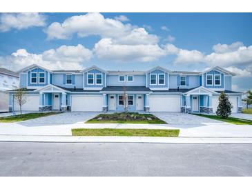 Charming blue townhomes featuring attached garages, stone accents, and manicured landscaping for curb appeal at 2529 Mario Way, Clearwater, FL 33761