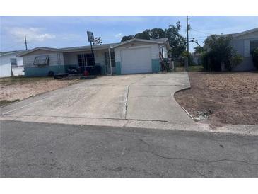 Modest one-story home featuring an attached garage, a front yard, and a basketball hoop at 4920 Zodiac Ave, Holiday, FL 34690