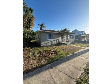Charming single-story home featuring a cozy front porch and a well-lit exterior at 1013 E Lake Ave, Tampa, FL 33605