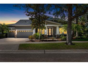 Charming home featuring a well-manicured lawn, two-car garage, and inviting front porch at twilight at 5313 Sanderling Ridge Dr, Lithia, FL 33547