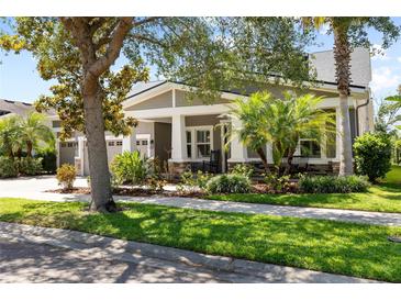 Charming single-story home with a well-manicured lawn, mature landscaping, and inviting front porch at 5313 Sanderling Ridge Dr, Lithia, FL 33547